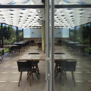 un restaurant avec des tables, des chaises et des fenêtres dans l'établissement Le Ville Relais, à La Spezia