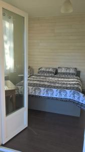 een slaapkamer met een bed en een glazen schuifdeur bij B&B Mob Mimizan On The Beach in Mimizan