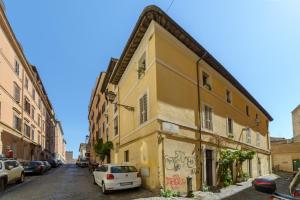 un edificio amarillo con coches aparcados en una calle en L'Olimpo di Estia, en Roma