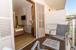 Habitación con balcón con silla y cama. en Eix Alcudia Hotel Adults Only, en Puerto de Alcudia