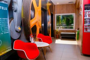 a restaurant with red chairs and a table in a room at ibis Asuncion in Asunción