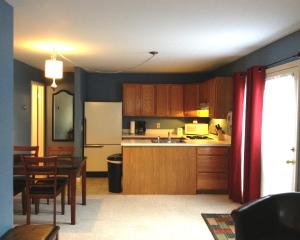 a kitchen with wooden cabinets and a table and a dining room at Vinehurst Inn & Suites in Hammondsport