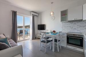 a living room with a table and a kitchen with a view at Apartments Sunset in Ražanj