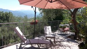 un patio con 2 sillas y una sombrilla en Affittacamere arabafenice, en Vezzano Ligure