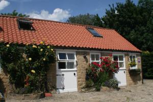 a small brick house with an orange roof at The Old Forge in Wilton