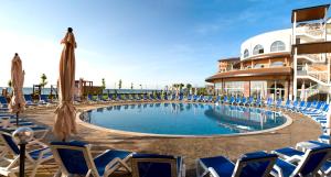 a pool with chairs and umbrellas in a resort at SOL by Meliá Luna Bay Resort - All Inclusive in Obzor