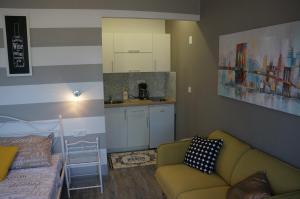 a living room with a couch and a kitchen at Apartments Valentino in Rab