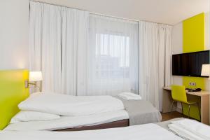 Habitación de hotel con 2 camas y TV de pantalla plana. en MediInn Hotel Oslo, en Oslo