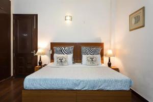 a bedroom with a large bed with two lamps at Perch Arbor Suites in Gurgaon +39 photos