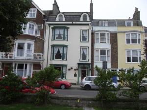 een groep huizen met auto's voor hen geparkeerd bij beaufort guesthouse in Weymouth