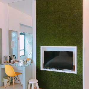 a living room with a flat screen tv on a green wall at 旅人空間The Cube Inn Homestay本民宿未與Agod a合作 We are not partnered with Agod a in Dongshan