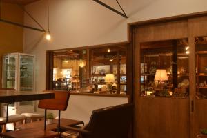 um restaurante com um bar com janelas de vidro em ILHA / ACCOMMODATION em Arita