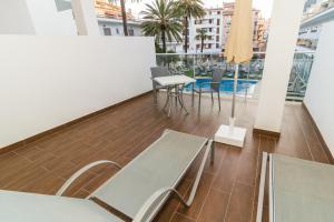 een balkon met tafels en stoelen in een gebouw bij Eix Alcudia Hotel Adults Only in Port d'Alcudia