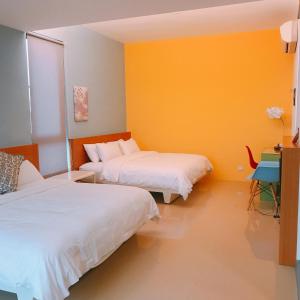 a room with two beds and a yellow wall at 旅人空間The Cube Inn Homestay本民宿未與Agod a合作 We are not partnered with Agod a in Dongshan +12 photos