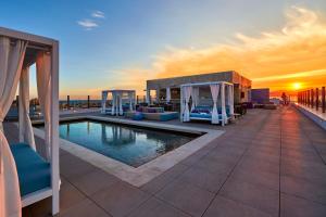 - une piscine sur le toit d'un immeuble avec vue sur le coucher du soleil dans l'établissement Indico Rock Hotel Mallorca - Adults Only, à Playa de Palma