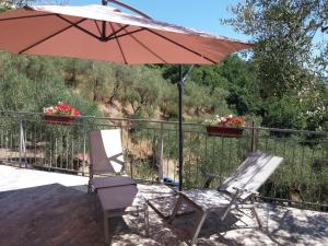 un patio con una silla y una sombrilla en Affittacamere arabafenice, en Vezzano Ligure