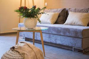 a dog laying in a living room with a table with a vase at Sundance Apartments & Suites in Hersonissos