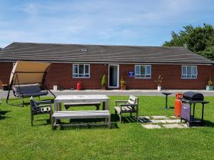 una mesa de picnic y sillas en un patio con una casa en Chelford Guesthouse, en Marthall