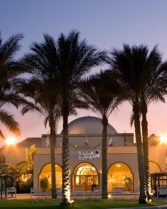 艾因蘇赫納的住宿－海星海洋俱樂部酒店，一群棕榈树在一座建筑前