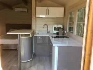 una cocina con encimeras blancas y fregadero en chalet golfe de st tropez en Grimaud