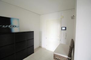 sala de estar con cómoda negra y TV en Dorya am Ring en Colonia