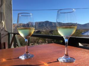 two glasses of white wine sitting on a wooden table at Die Dorpshuis in Calitzdorp