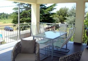 a glass table and two chairs on a porch at Apartments Villa Lili in Umag
