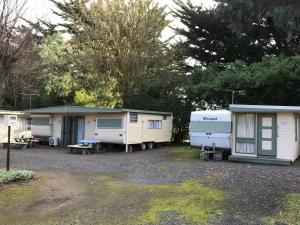 a group of mobile homes parked in a parking lot at Pinewood Caravan Park in Heywood +18 photos