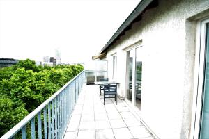 a balcony with chairs and a table on a building at Dorya am Ring in Cologne