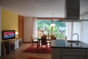 a kitchen and dining room with a table and a television at Appart Saroja-Tannleger in Brand