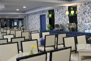 ein Esszimmer mit weißen Stühlen und Tischen in der Unterkunft Coração de Fatima Boutique Hotel in Fátima