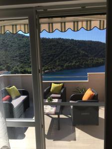 a balcony with chairs and a view of the water at Apartments Ladesta in Lastovo