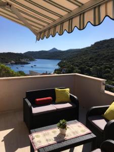 a balcony with a couch and a table with a view at Apartments Ladesta in Lastovo