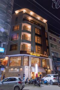 un edificio con auto parcheggiate di fronte di Sangai Continental (The Boutique Hotel) a Imphal