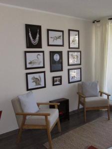 una sala de estar con 2 sillas y cuadros en la pared en Departamento en Pucon, en Pucón
