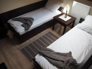 sypialnia z 2 łóżkami i stołem z lampką w obiekcie Willa Zacisze - Apartament dwupoziomowy w mieście Kalwaria Zebrzydowska