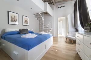 um quarto branco com uma cama azul e uma escada em Central Station Lovely apartment em Florença