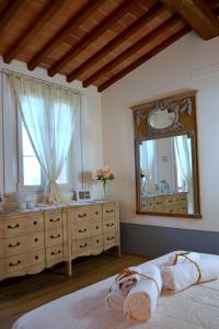 een slaapkamer met een bed en een grote spiegel bij Elisabeth House in Lucignano