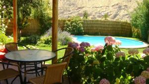 a garden with a table and chairs and a swimming pool at Casa Arun in Pisco Elqui