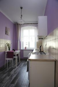 マルボルクにあるApartament Zapiecekの紫の壁のキッチン、テーブル、窓