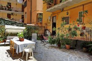 un patio al aire libre con mesa, sillas y plantas en Pretty Flat Trastevere, en Roma