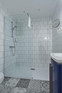 a white bathroom with a shower and a toilet at Florella Marceau Apartment in Cannes