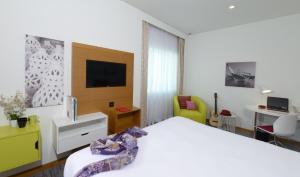 ibis Styles Manama Diplomatic Area في المنامة: غرفة فندق بسرير وتلفزيون