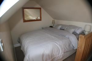 a bedroom with a white bed with a mirror at The Old Forge in Wilton