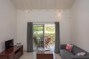 a living room with a couch and a tv at Blue Marlin Apartments in Willemstad