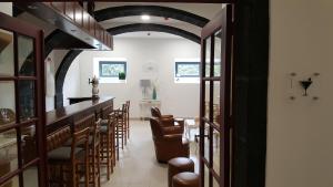 a room with a bar with chairs and a counter at Solar Do Conde Garden Hotel in Capelas