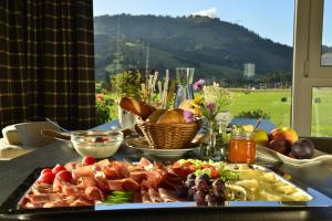 einen Tisch mit einem Tablett mit Essen auf dem Tisch in der Unterkunft Fairhotel Hochfilzen B&B in Hochfilzen