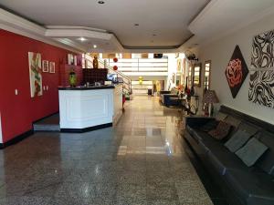 a lobby with a couch and a bar in a building at Pluma Hotel Cidade in Americana