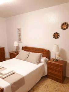 1 dormitorio con 1 cama blanca y 2 mesitas de noche en Apartamento Gran Vía Cehegín en Cehegín