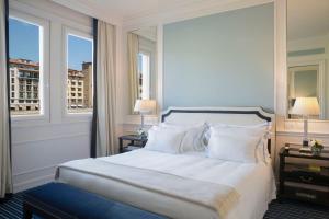 a hotel room with a large bed and a large window at Hotel Lungarno - Lungarno Collection in Florence